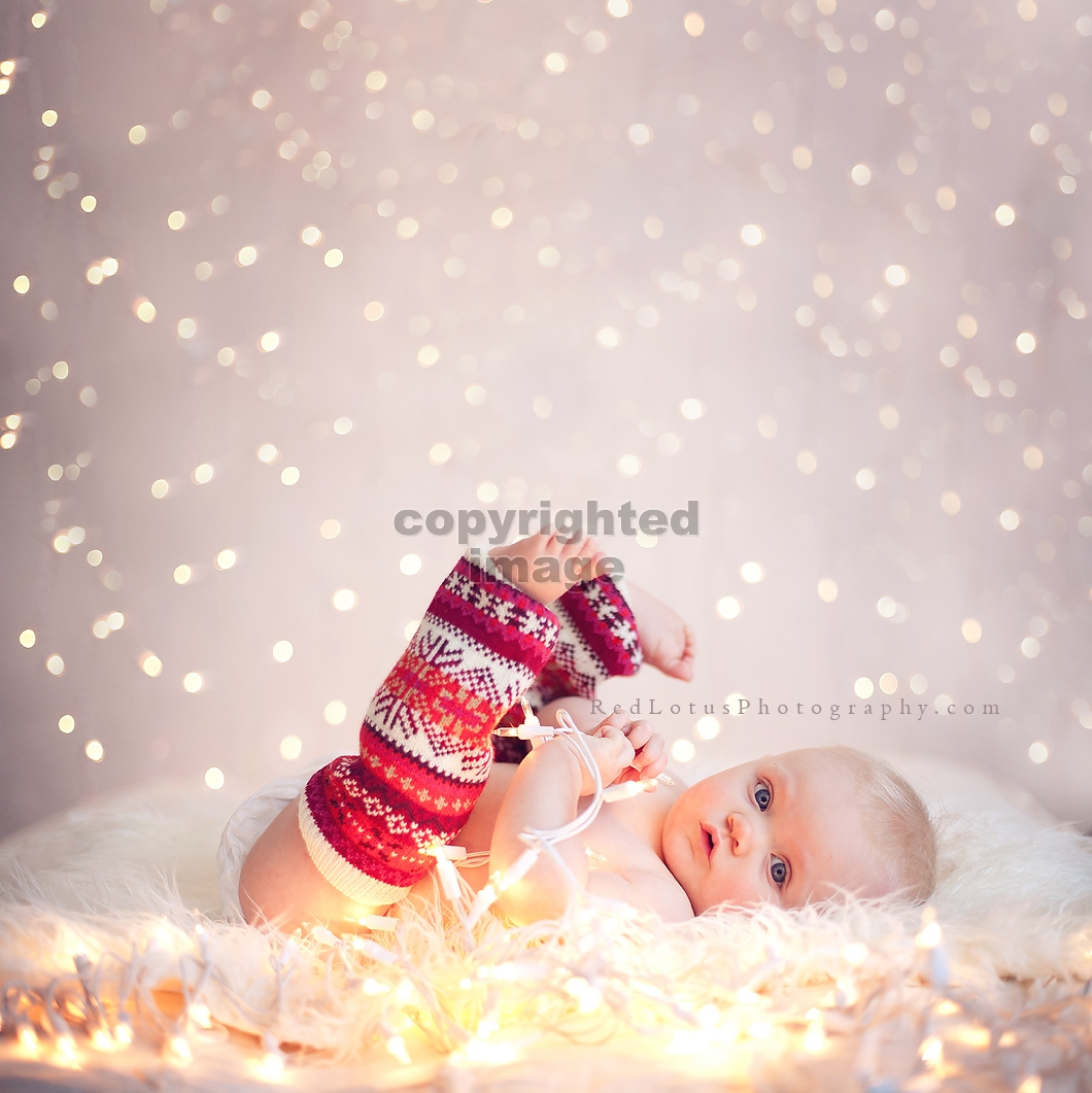 baby in front of a twinkle light backdrop