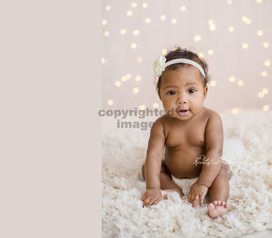 baby with twinkle lights backdrop